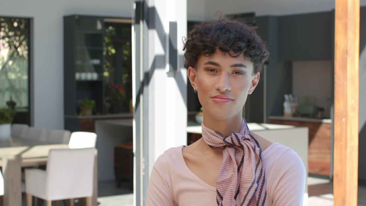 Standing confidently in modern home, smiling non binary person