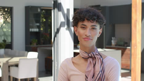 standing confidently in modern home, smiling non binary person