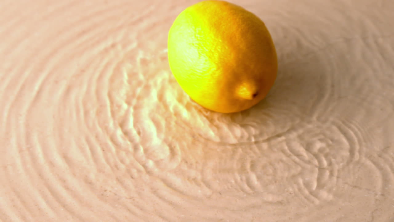 Lemon spinning on wet white surface