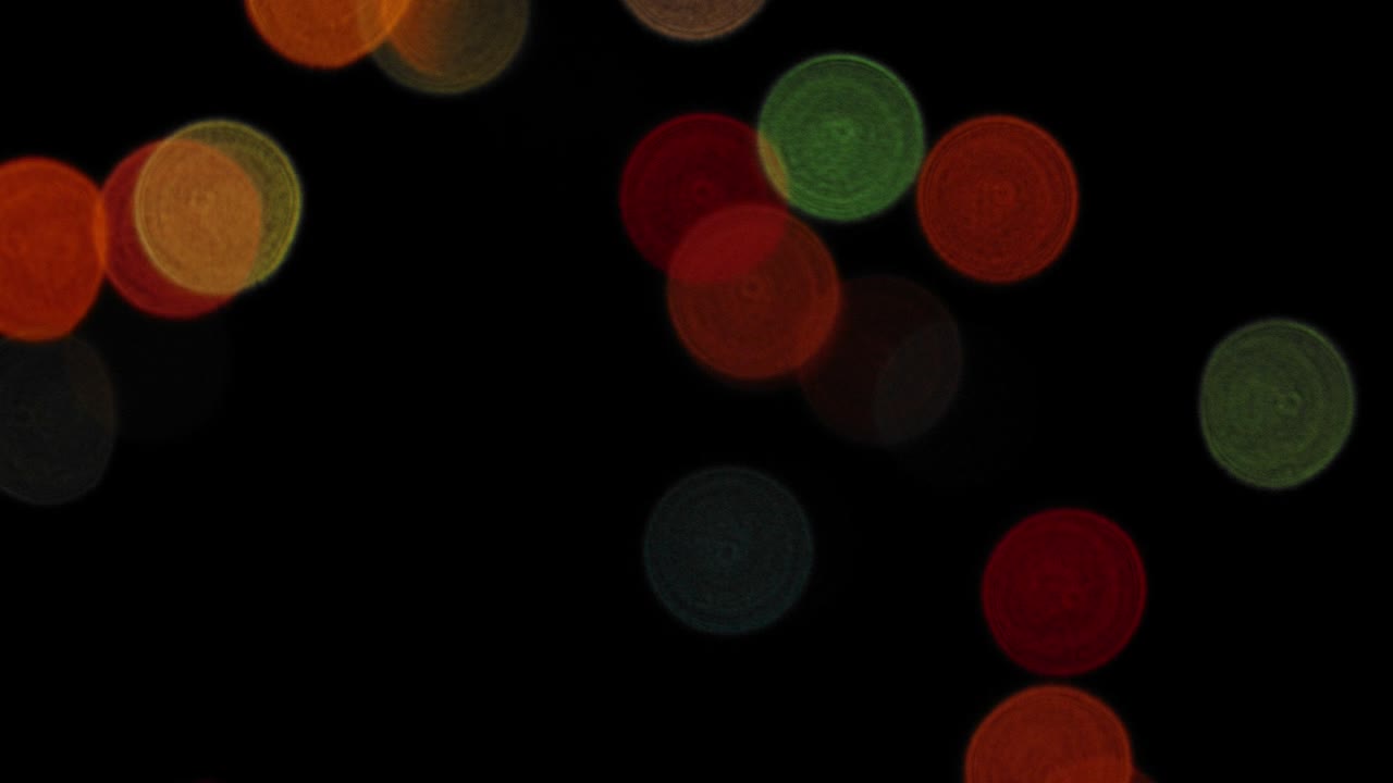 las luces de colores parpadeantes desfocadas se mueven contra un fondo oscuro. bokeh.