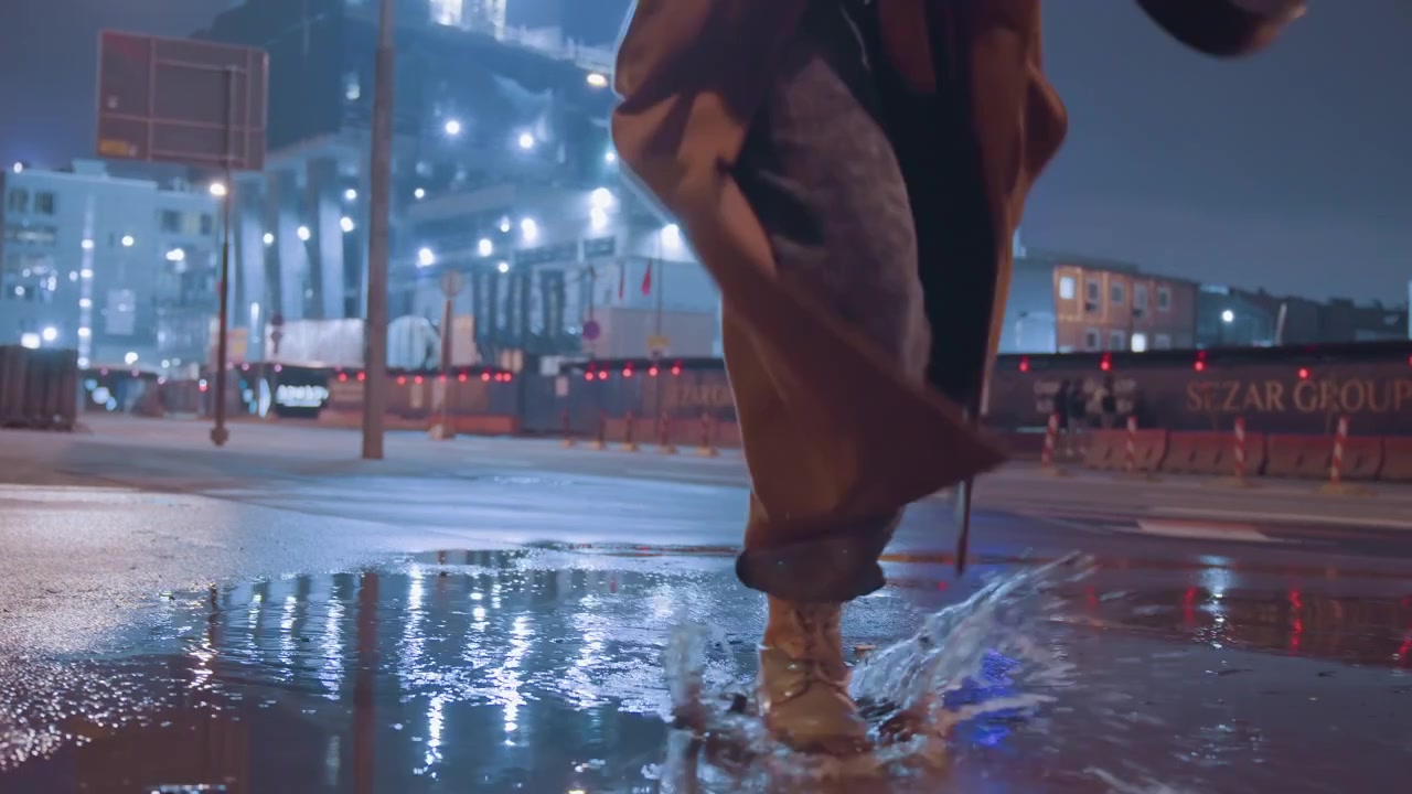 Musicista riflessivo che passeggia lungo strade illuminate da vivaci luci al neon. Musicista di strada solitario che cammina con determinazione attraverso un paesaggio urbano malinconico illuminato da riflessi neon colorati.