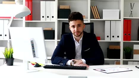 giovane uomo d'affari che guarda la telecamera in un ufficio moderno