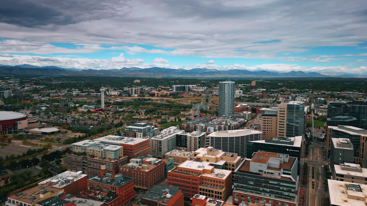 Denver, USA, 28 July 2025: Modern urban landscape of Denver, Colorado, USA. Blue sky is covered with grey clouds. Mountain range at backdrop