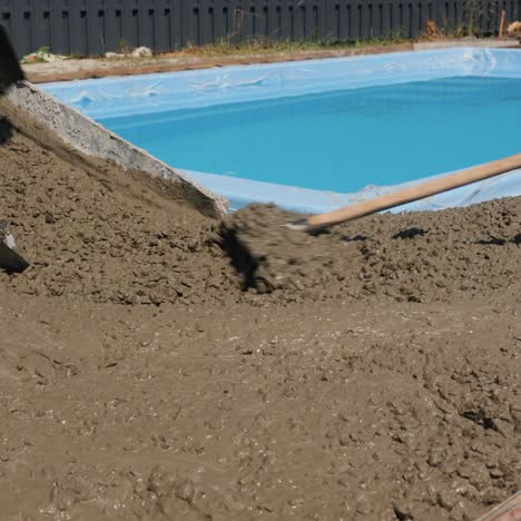 Beton-Fließt-Die-Dachrinnen-Hinunter,-Wo-Arbeiter-Pflaster-Herstellen-6