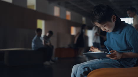 preteen schoolboy playing online game on school break. boy using tablet computer