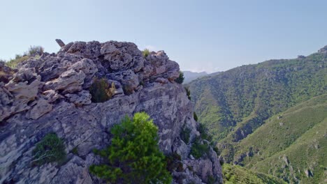 Low-flight-over-cliffs-and-panoramic-view-of-forested-mountains-and-mist