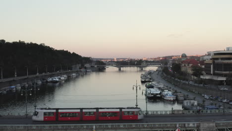 Moderne-Straßenbahn-Fahren-Auf-Einer-Brücke-über-Die-Moldau,-Prag,-Tschechien