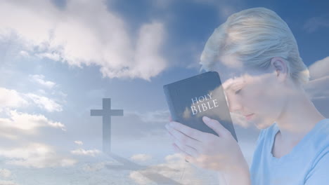 animation of cross and caucasian woman holding bible over blue sky with clouds