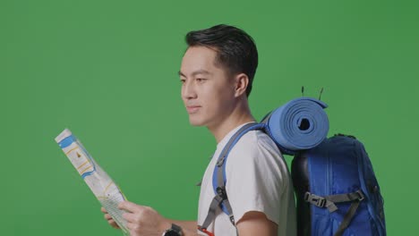 man reading a map with a backpack