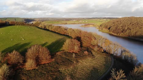 aerial forward shot of a hill overlooking wimbleball lake exmoor england on a sunny autumn evening