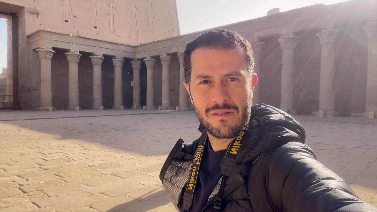 Coppia di turisti che registra un video selfie all'interno del Tempio di Horus a Edfu, Egitto. Viaggiatori del mondo. Creatori di contenuti. Fotografo con macchina fotografica che fa un tour a 360 gradi del tempio egizio. Voglia di viaggiare. Viaggiatore.
