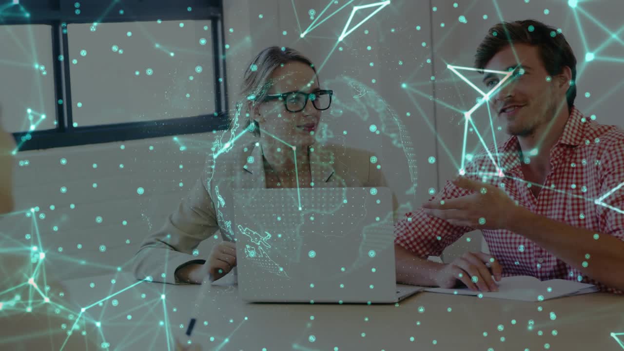 Woman and man sitting at tech table, man gesturing starting globe aligning over laptop showing data