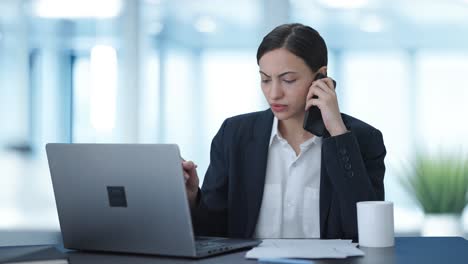 Serious-Indian-female-manager-talking-on-mobile-phone