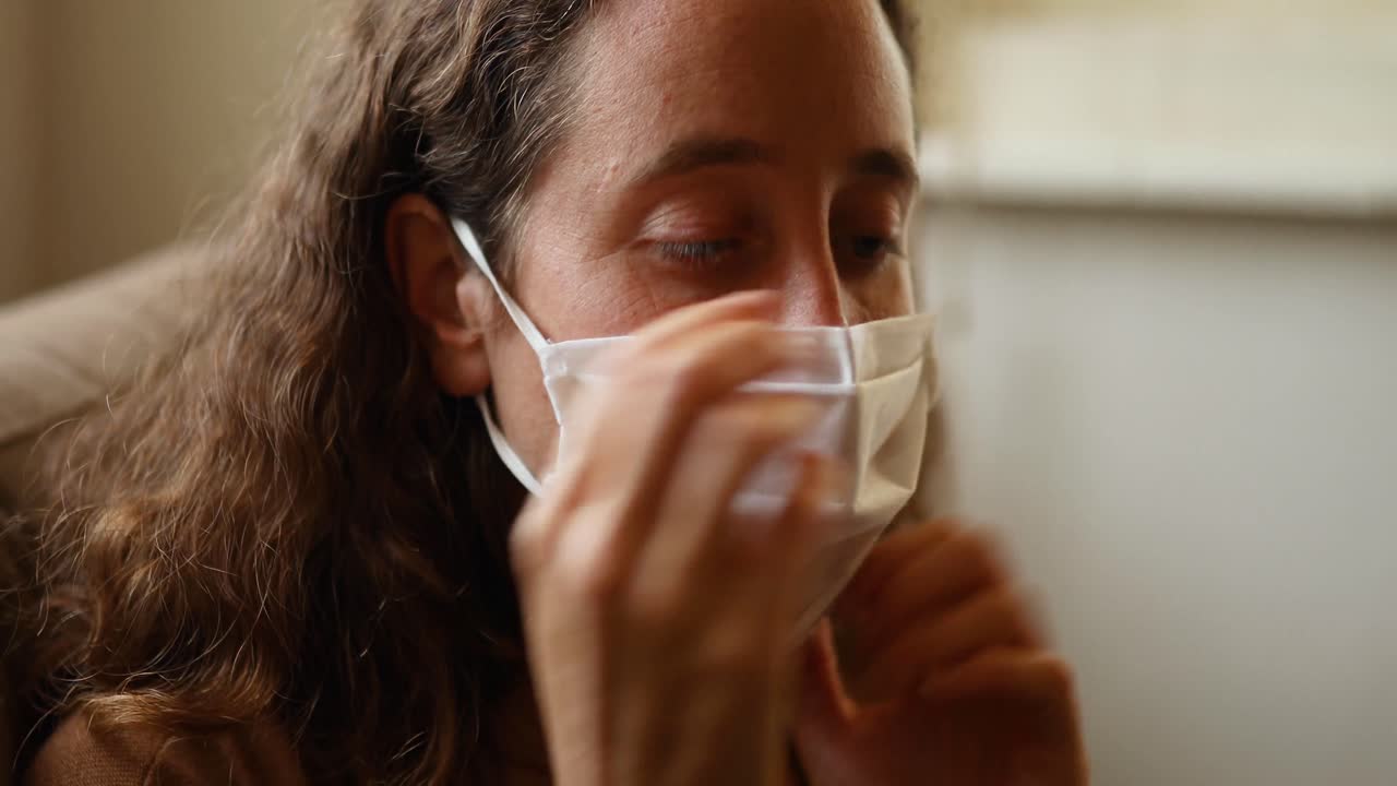Donna caucasica che indossa una mascherina a casa