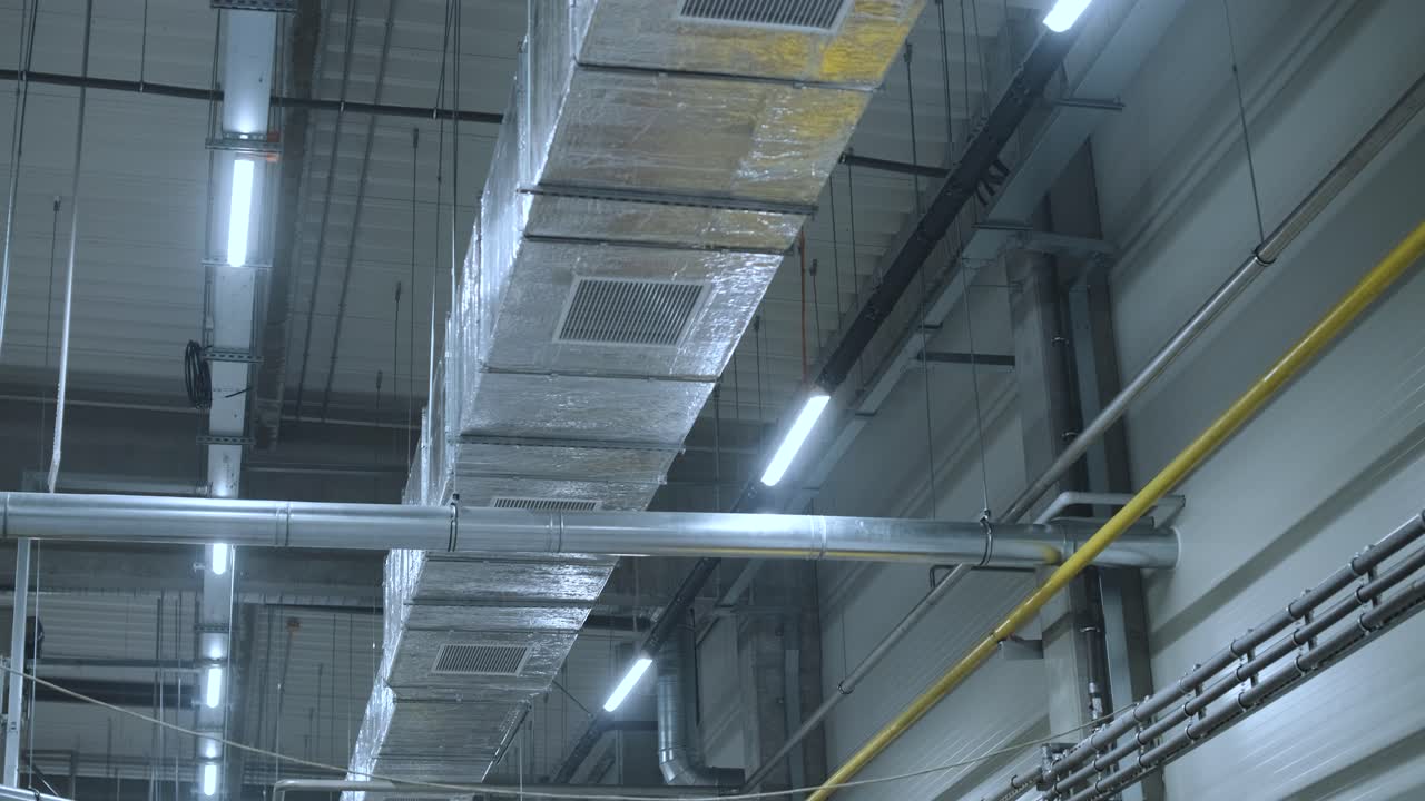 HVAC Duct Cleaning, Ventilation pipes in silver insulation material hanging from the ceiling inside new building.