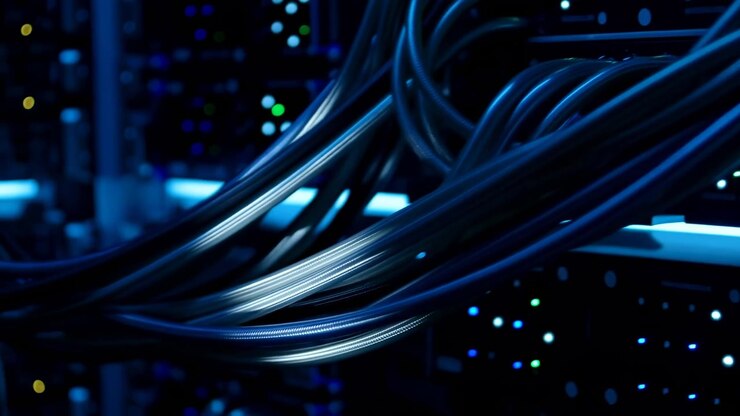 Flettede serverkabler ført fra sideporte strækker sig over et rack under blå LED-belysning med subtil skiftende bevægelse, blanke refleksioner og oplyste statusindikatorer inde i et moderne datacenter.
