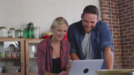 Young-white-couple-on-line-shopping-in-kitchen,-waist-up,-shot-on-R3D