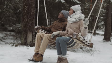 couple enjoying a snowy swing