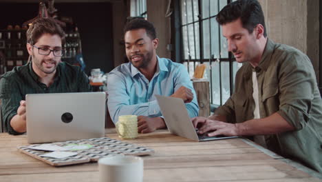 Three-Male-Designers-In-Meeting-Using-Laptops