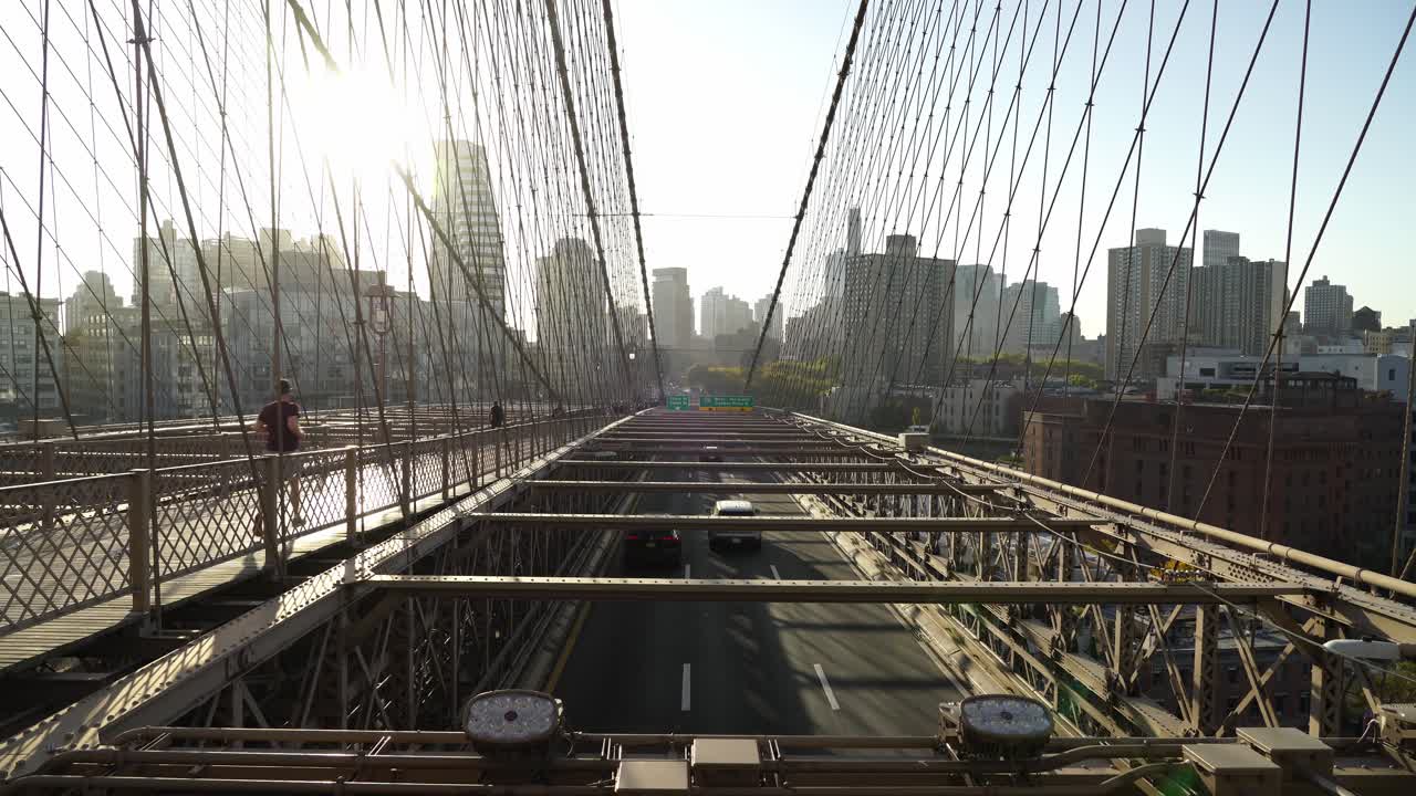 Commuters Crossing Brooklyn Bridge in New York on a Sunny Evening