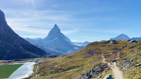 Mountain-Freedom:-Matterhorn-Mountain-Landscape-Near-Rotenboden-and-Gornergart,-Switzerland,-Europe-|-Shaky-Movement-Down-Trail-Near-Scenic-Lake,-Almost-Falling,-Hiking