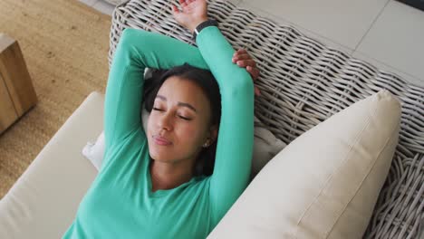 african american woman lying on the couch at home