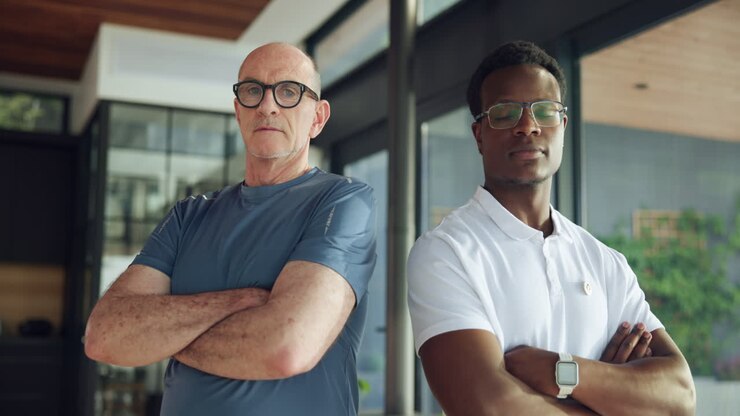 Homens diversos e confiantes em pé, de braços cruzados e olhando para a câmera