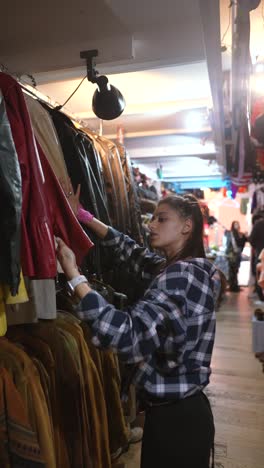 woman browsing vintage clothing in a thrift store