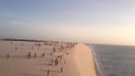 drone flying over beachgoers tourists on a sand dune in jericoacoara, brazil