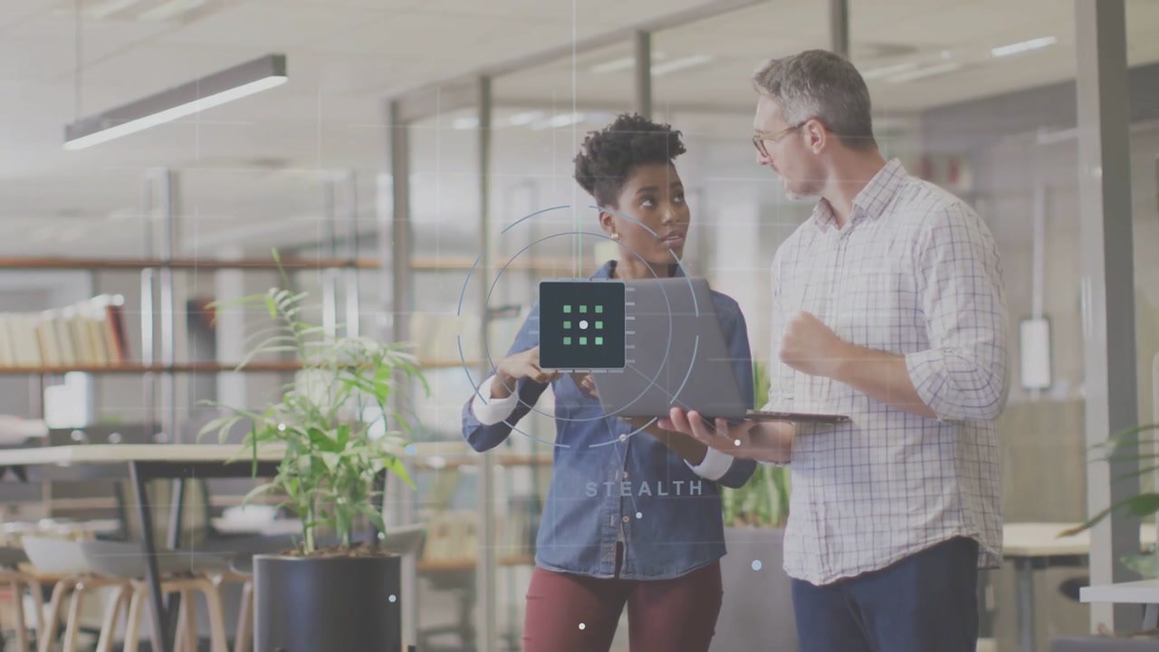Swiping woman in blue shirt, burgundy pants holding laptop in office, man pointing at UI overlay