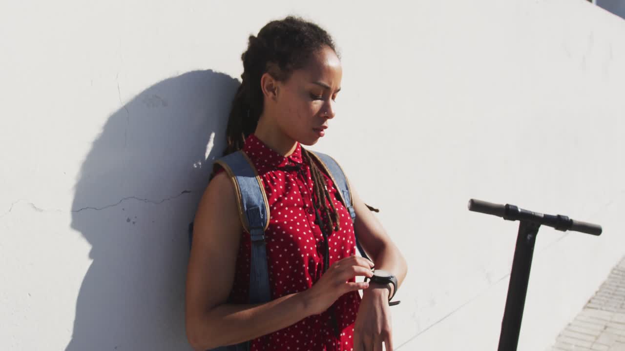 해변의 산책로에서 스마트 워치를 사용하는 아프리카계 미국인 여성