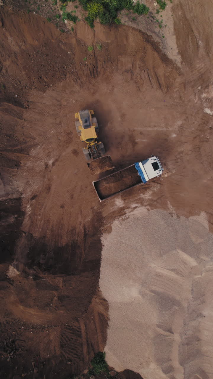 Construction site aerial vertical footage excavator heavy machinery coastal residential development Mediterranean seaside building project housing infrastructure