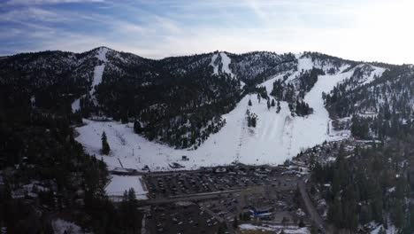 Aerial-wide-panning-shot-of-Bear-Mountain-ski-resort-during-the-winter-in-Big-Bear-Lake,-California