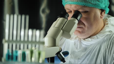 test tubes in the lab as a man works with a microscope 2