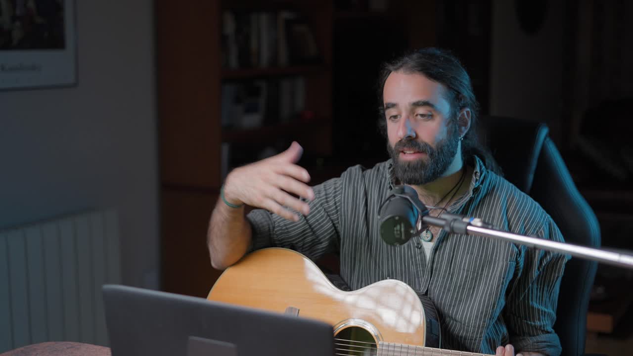 Man playing acoustic guitar and singing in a home studio