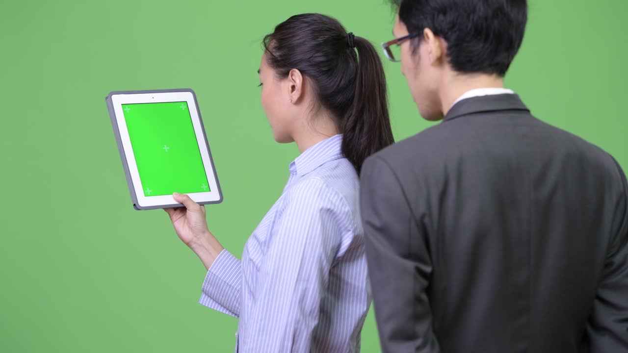 Young Asian business couple using digital tablet together