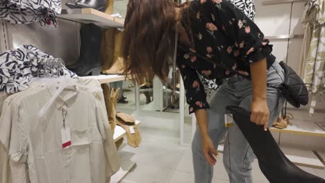woman shopping for clothes and shoes in a retail store