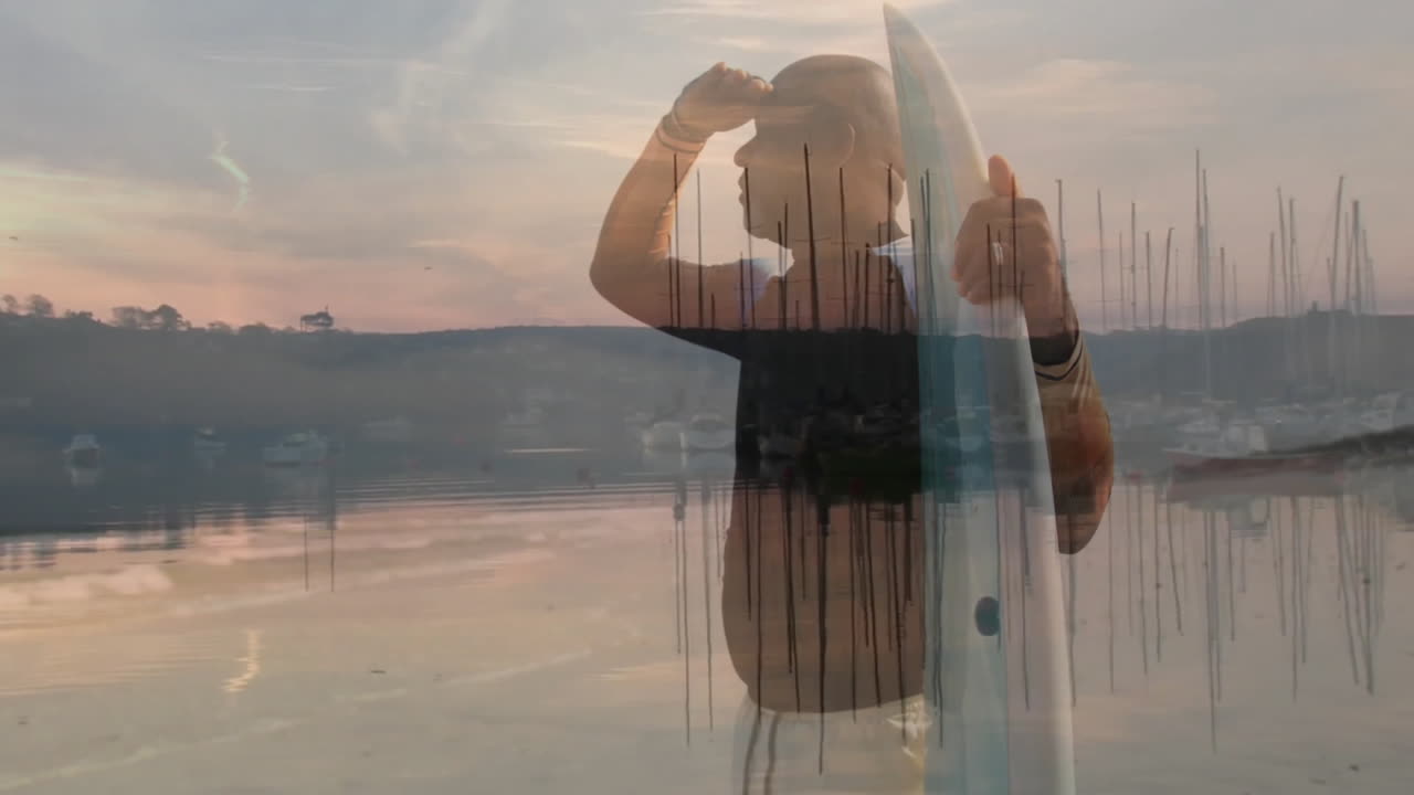 Senior man holding surfboard scanning harbor at sunset with floating health icons and data chart