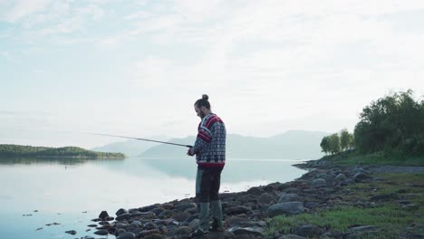 a man with fishing road at the lake near vangsvika, senja norway