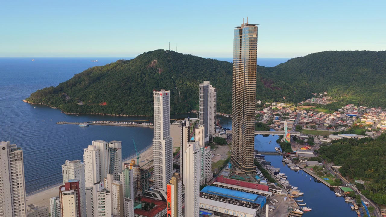 Arranha-céus dominam Balneário Camboriú com uma marina à vista. A luz da manhã realça a vibrante paisagem urbana. Ideal para conteúdo de desenvolvimento urbano ou viagens.