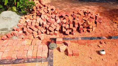 the red blocks were piled up, construction using earthen blocks, building the foundation of the house, workers work at a construction site in india, building a house with red stone