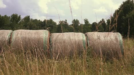 slow motion video of harvested round hay bales in an open field