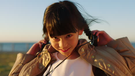 Child,-face-smile-and-beach-with-headphones