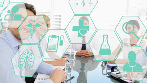 animation of medical icons in hexagons over caucasian partners shaking hands in board room