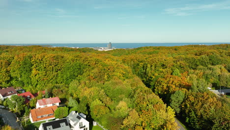 elevated view of a vibrant forest with a coastal city skyline sea towers and sea in the background, showcasing the beauty of gdynia's natural and urban landscape