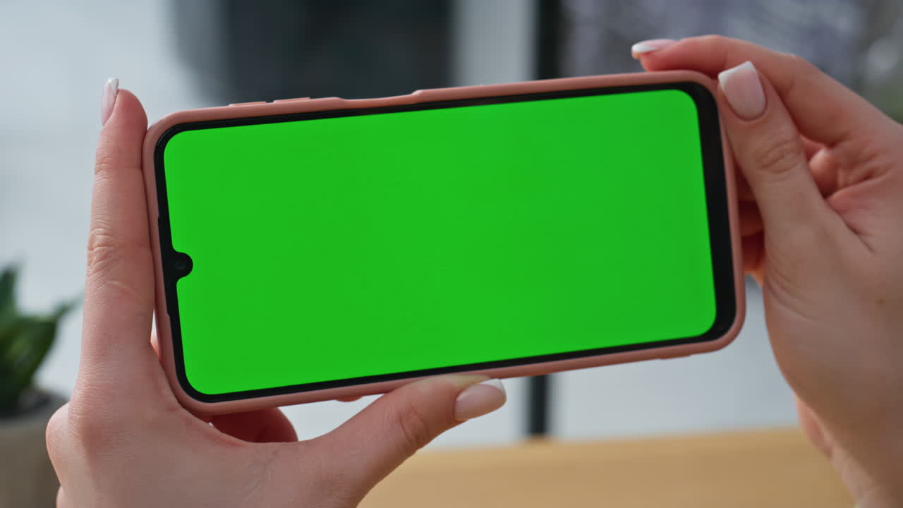 Hands holding horizontal mockup mobile phone at corporate workplace closeup