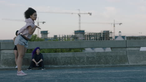 Mujer-Bailando-Atractiva-Joven-Bailarina-De-Raza-Mixta-Realizando-Baile-Callejero-De-Estilo-Urbano-En-La-Ciudad-Practicando-Movimientos-De-Estilo-Libre-Amigos-Viendo-Disfrutar-Pasar-El-Rato-Juntos-Al-Atardecer