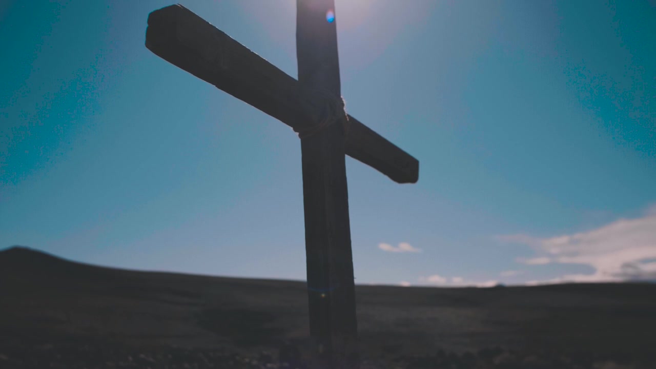 Wooden Christian Cross Silhouette Against Bright Blue Sky