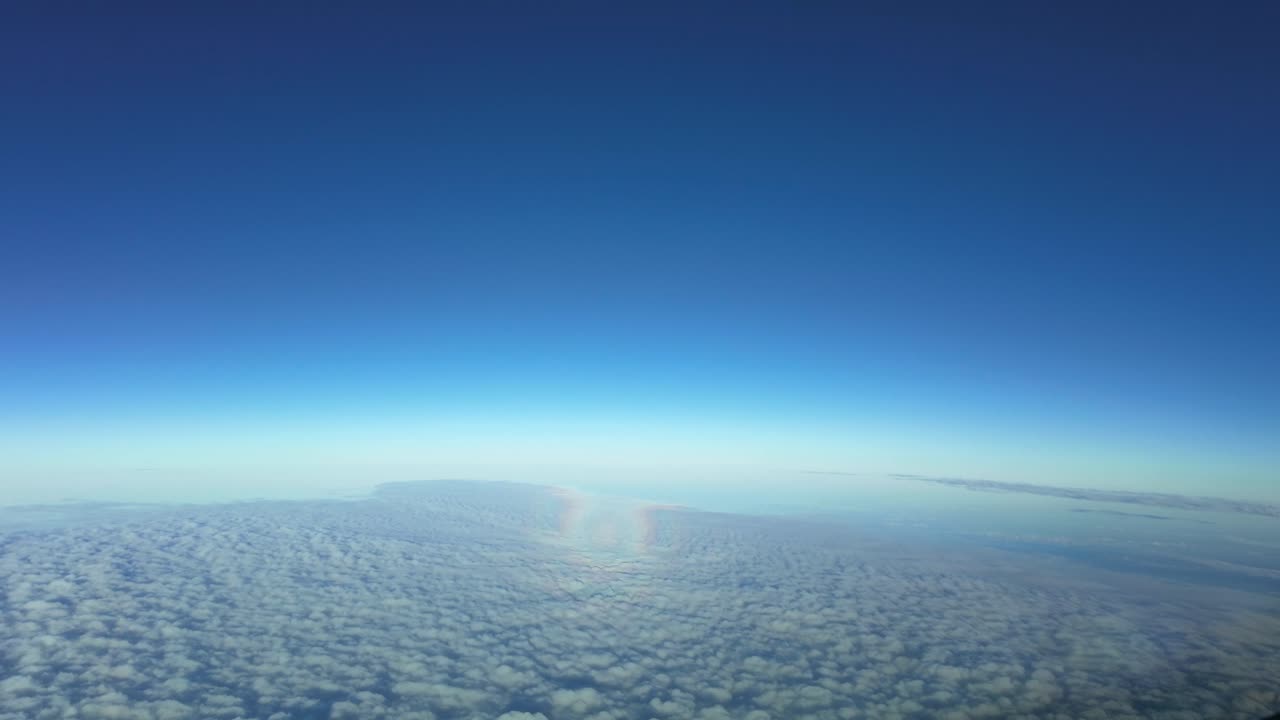 뒷면에 태양이 있는 오스 스트라투스 구름 층 위를 날아다니는 제트 항공기의 헤일로의 공중 포브