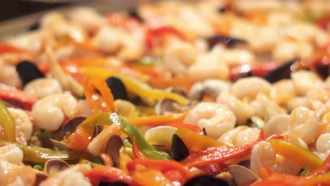 la gran inauguración de una vasta y ondulante obra maestra de paella, meticulosamente elaborada y graciosamente servida dentro de los opulentos límites del espectáculo gastronómico de un famoso restaurante.